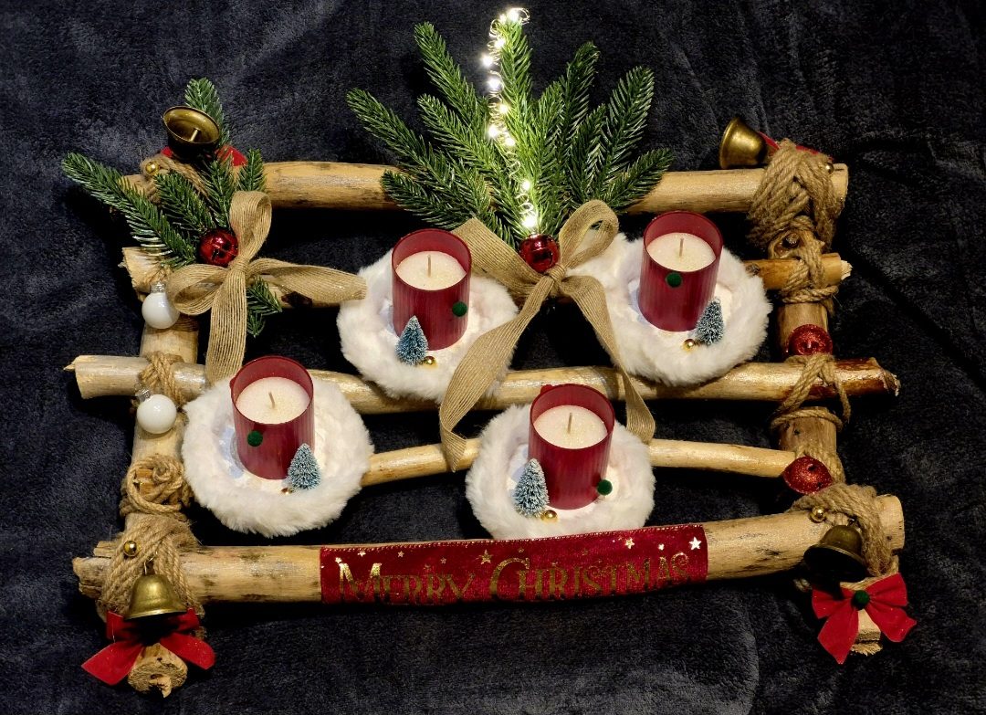 Décoration de Noël avec quatre bougies sur un support en bois et des éléments naturels.